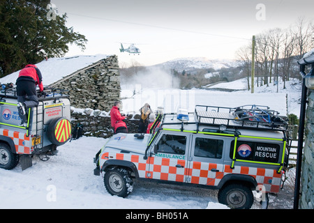 Bergrettung und Air Ambulance evakuieren ein verletzter Wanderer von Langdale im Lake District, UK. Stockfoto