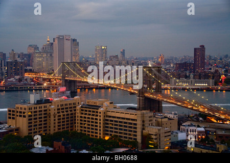 Lichter funkeln in der Abenddämmerung in Lower Manhattan und im New Yorker Stadtteil Brooklyn Bridge. Stockfoto