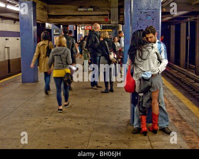 Gleichgültig gegenüber ihrer Umgebung, ein junges Paar küssen in New York Citys 2nd Avenue u-Bahnstation. Stockfoto