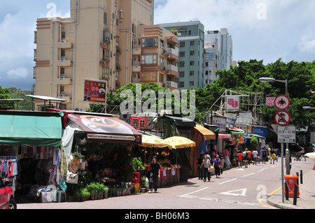 Käufer zu Fuß durch eine Reihe von Open-Air Ladenfronten entlang Stanley Market Road, Stanley Market, Stanley, Hong Kong, China Stockfoto