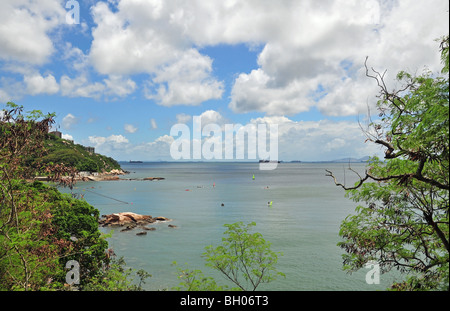 Blauer Himmel weiße Wolken Blick auf Stanley Bay durch grüne Bäume von Wong Ma Kok Road, Stanley, Hong Kong, China Stockfoto