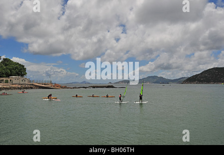 Windsurfer und Kanuten auf dem ruhigen Wasser der Stanley Bay, Stanley, Hong Kong, China Stockfoto