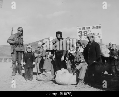 Flüchtlinge in 38. Breitengrades für Schmuggelware überprüft, bevor es ihnen ermöglicht, die 38. überqueren Parallel Brücke während des Koreakrieges. Stockfoto