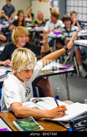 Eine Blondine hält begeisterten acht Grade junge seine Hand eine Frage in der Klasse an einer Mittelschule in Südkalifornien. Stockfoto