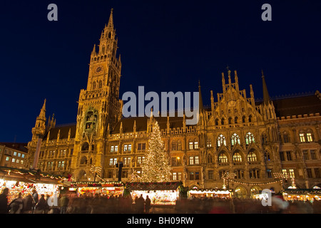 Christkindlmarkt (Weihnachtsmarkt) in den Marienplatz außerhalb der Neues Rathaus (New City Hall) in der Abenddämmerung in der Stadt München Stockfoto