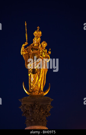 Goldene Statue der Jungfrau Maria auf der Mariensäule in der Marienplatz in der Abenddämmerung in der Stadt München (München), Bayern, Deutschland Stockfoto