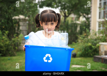 Mädchen hält Kiste mit leeren Plastikflaschen für Recycling Stockfoto
