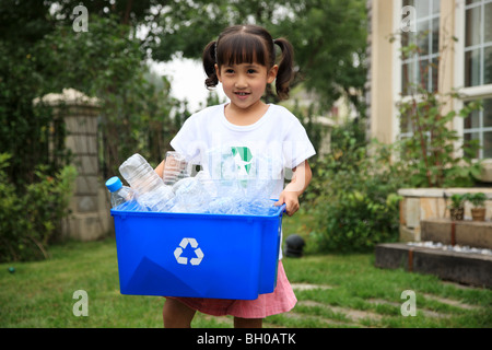 Mädchen hält Kiste mit leeren Plastikflaschen für Recycling Stockfoto