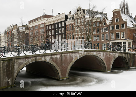 Brücke und Häuser auf gefrorenen Keizersgracht Kanal in Amsterdam Stockfoto