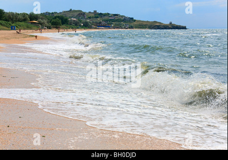 Meer große Surfwelle brechen auf Küste und Cape mit Pavillon im Abstand Stockfoto