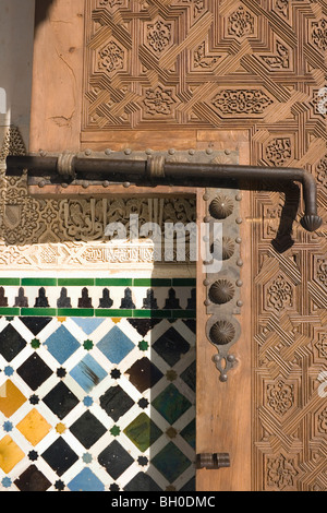 Palast von Alhambra, Granada, Andalusien, Spanien. Detail der geschnitzten Holztür, Bolzen und Wand. Stockfoto