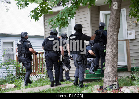 Polizei taktische Team Eintrag um eine risikoreiche Droge verwandte Durchsuchungsbefehl zu dienen. Straße Drogen Einheit. Stockfoto