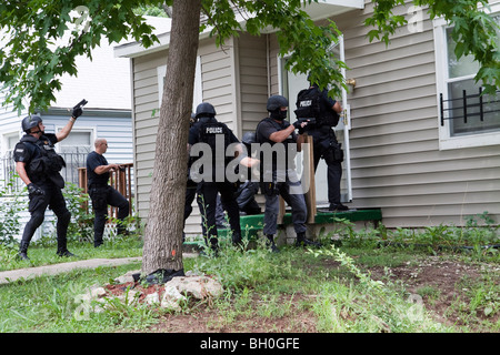 Polizei taktische Team Eintrag um eine risikoreiche Droge verwandte Durchsuchungsbefehl zu dienen. Straße Drogen Einheit. Stockfoto