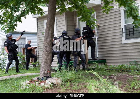 Polizei taktische Team Eintrag um eine risikoreiche Droge verwandte Durchsuchungsbefehl zu dienen. Straße Drogen Einheit. Stockfoto