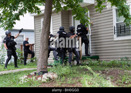 Polizei taktische Team Eintrag um eine risikoreiche Droge verwandte Durchsuchungsbefehl zu dienen. Straße Drogen Einheit. Stockfoto