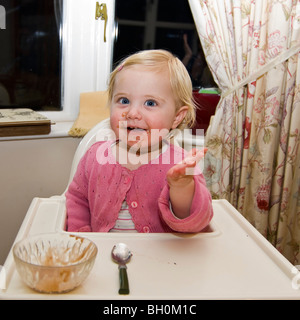 Platz in der Nähe bis Porträt eines Mädchens in einem Durcheinander in ihrem Hochstuhl Schokoladeneis zu essen bekommen. Stockfoto