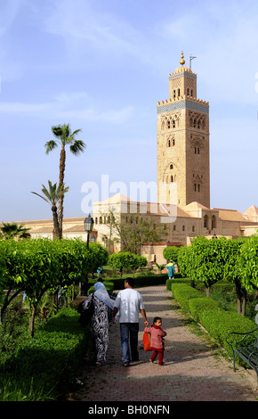 Familie in einem Park vor das Minarett der Koutoubia-Moschee, Marrakesch, Süden von Marokko, Marokko, Afrika Stockfoto