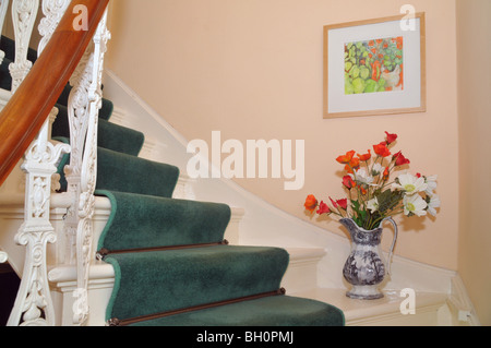 Geländer und Teppichboden Treppenhaus mit floralen Ornamenten und hängenden Bild. Stockfoto