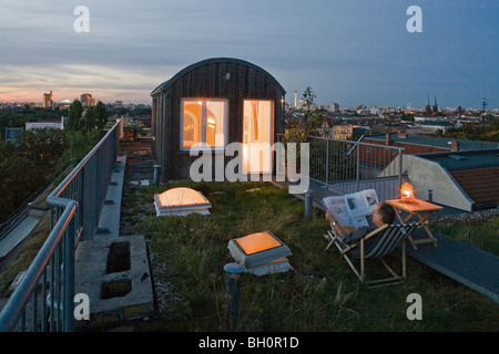 Mann liest Zeitung auf einer Dachterrasse, Berlin, Deutschland Stockfoto