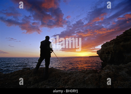 Angler an der felsigen Küste Algar Seco bei Sonnenuntergang, Algarve, Portugal, Europa Stockfoto