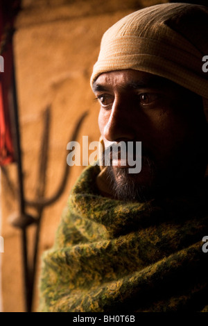 Eine Dom, eines der hinduistischen Kaste beteiligt Einäscherung der Toten steht an der Quelle der ewigen Flamme in Varanasi, Indien. Stockfoto