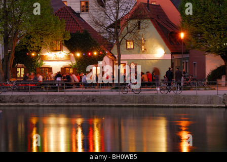 Blick über den Fluss Isar zu einem beleuchteten Biergarten, Landshut, untere Bayern, Bayern, Deutschland Stockfoto