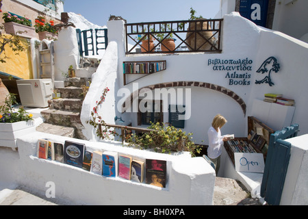 Frau in Atlantis Bücher Buchhandlung im Sonnenlicht, Oia, Santorini, Griechenland, Europa Stockfoto