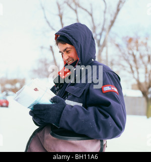 Briefträger, die Zustellung von Briefen außerhalb an einem verschneiten Tag im Winter Ontario Kanada KATHY DEWITT Stockfoto