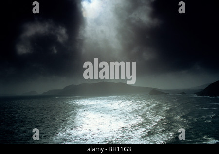 Sonnenstrahlen durchscheinen dunkle Wolke Abdeckung in Dingle Bay, Great Blasket Island, County Kerry, Irland, Europa Stockfoto