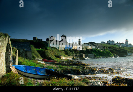 Häuser und Leuchtturm an der Küste unter Donner Wolken, Roche Point, County Cork, Irland, Europa Stockfoto