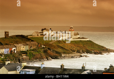 Häuser und Leuchtturm an der Küste in den Abend, Roche Point, County Cork, Irland, Europa Stockfoto