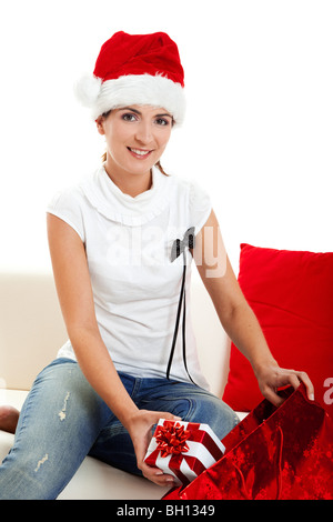 Junge Frau auf einem Sofa Eröffnung Weihnachten präsentiert Stockfoto