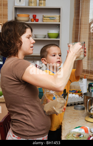 Mutter und Sohn arbeiten zusammen in der Küche sichern einen Kuchen - Model-Release verfügbar Stockfoto