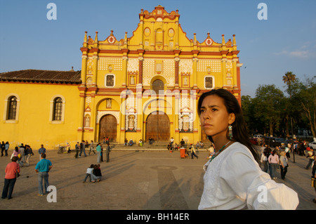 Eine Frau gekleidet in Tradiniotal mexikanische Kleidung steht mit Kirche im Hintergrund San Cristobal de Las Casa, Chiapas. Mexiko Stockfoto