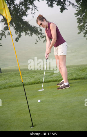 Frau in ihrer Mitte der 20er Jahre Golf spielen Stockfoto