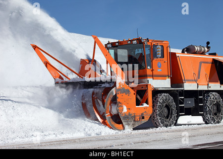 Schneefräse Fahrzeug Bergstraße Schnee entfernen. Großes Fahrzeug drehenden  Messer wirft Eis und Schnee von der Straße Stockfotografie - Alamy