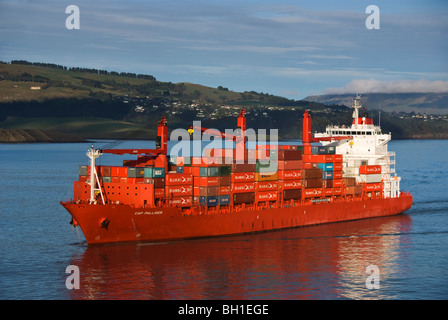 Ein Containerschiff fährt vom Hafen an einem ruhigen und sonnigen Tag. Stockfoto