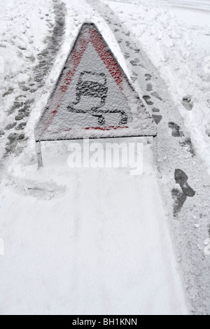 Zeichen im Schnee Gefahren Warnung Rutschgefahr auf Straße Stockfoto