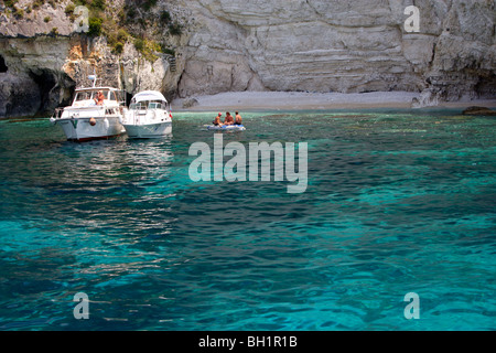 Boote ankern vor Höhlen an der Westküste, Paxos, Ionische Inseln, Griechenland Stockfoto