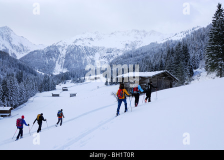 Backcounty Skifahrer auf Almwiese mit Heustadel, Wiedersberger Horn, Kitzbüheler Alpen, Tirol, Österreich Stockfoto