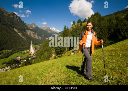 Frau wandern über Alp über Heiligenblut mit Wallfahrt Kirche Zum hl. Pluet, Blick zum Großglockner, Heiligenblut, Carinthia, A Stockfoto