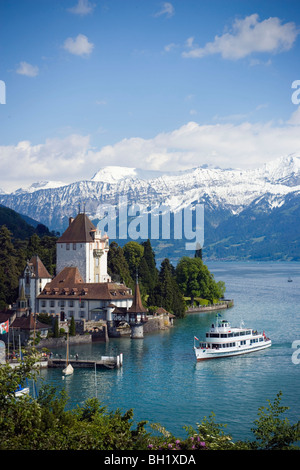 Ausflugsschiff im Schloss Oberhofen am Thunersee, Eiger (3970 m), Mönch (4107 m) und Jungfrau (4158 m) im Hintergrund, Oberhofen, Stockfoto