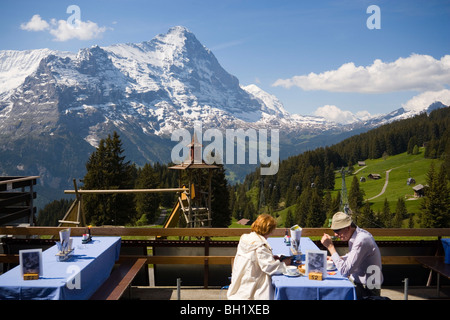 Paar, sitzen auf der Terrasse des Bergrestaurants Berghaus Bort (1600 m), zuerst, Eiger (3970 m) im Hintergrund, Grindelwald, B Stockfoto