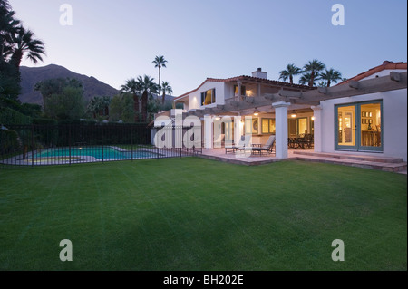 Liegewiese und Swimmingpool mit beleuchteten Fassade von Palm Springs nach Hause außen Stockfoto