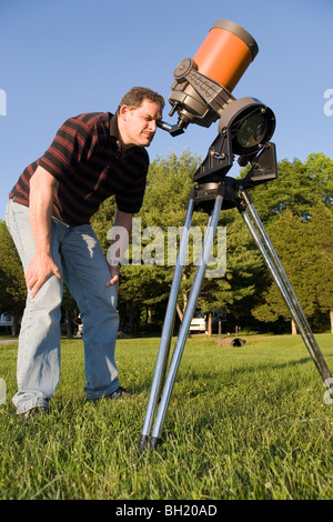 Ein Mann, der Blick durch ein Teleskop. Stockfoto