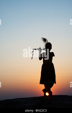 Silhouette eines indischen Mädchens vorgibt, Lord Krishna bei Sonnenuntergang. Andhra Pradesh, Indien Stockfoto