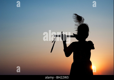 Silhouette eines indischen Mädchens vorgibt, Lord Krishna bei Sonnenuntergang. Andhra Pradesh, Indien Stockfoto