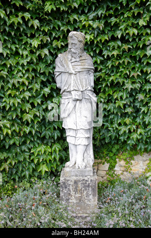 Eine klassische Statue mit einer Efeu-Hecke im Hintergrund Stockfoto