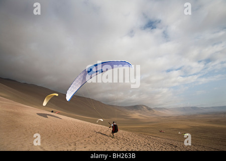 Zwei Personen, parasailing und landen in der Wüste Stockfoto