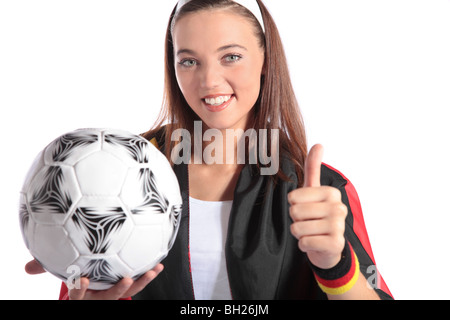 Eine attraktive deutsche Fußball-Fan trägt mehrere Fan-Utensilien und hält einen Fußball. Alle isoliert auf weißem Hintergrund. Stockfoto